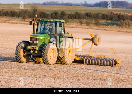 Le ratissage du tracteur dans le champ du sol crayeux Banque D'Images