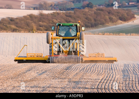 Le ratissage du tracteur dans le champ du sol crayeux Banque D'Images