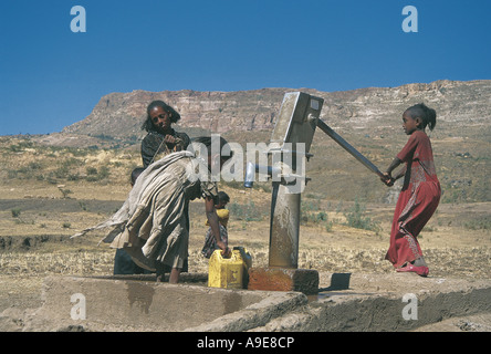 Femme et deux jeunes filles 2 Organisation des Nations Unies d'exploitation de la pompe à eau installée à Mekele, Ethiopie Banque D'Images