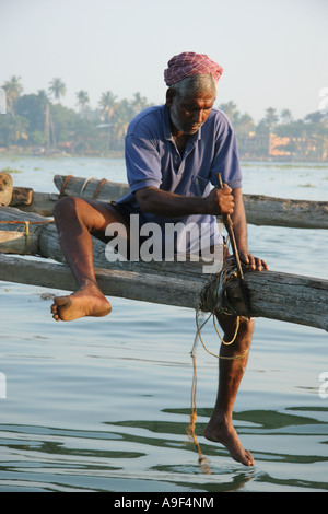 La réparation du pêcheur filets de pêche chinois à Kochi (Cochin), Kerala, Inde du Sud Banque D'Images