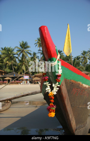 Bateau de pêche local avec une guirlande de soucis de suspension c'est Bow sur la plage de Palolem, le Sud de Goa, Inde Banque D'Images