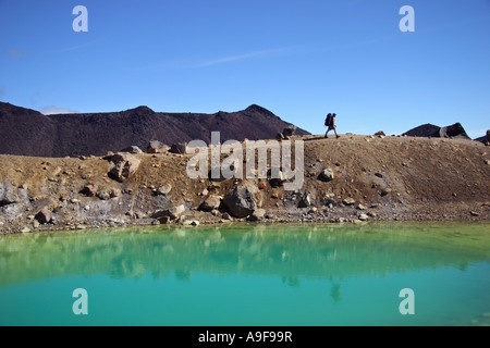 Un randonneur fait son chemin au-delà des lacs d'Émeraude sur le Tongariro crossing à l'Île du Nord, Nouvelle-Zélande Banque D'Images