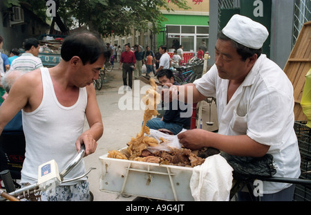 CHN Chine Pékin Pékin Ancien vendeur de viande sur un marché de rue dans un hutong du district Xicheng Banque D'Images