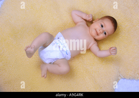 Bébé couché sur le tapis en peau de mouton Banque D'Images