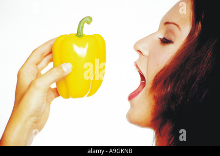 Young woman biting darkhaired un piment fort Banque D'Images