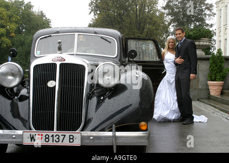 Young couple debout à côté d'un oldtimer. Banque D'Images