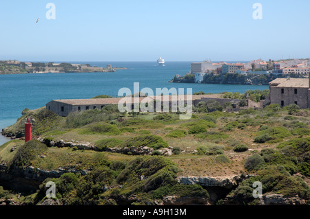 Bateau de croisière régate approchant de l'entrée de port Mahon, Menorca, Espagne, à l'ensemble de l'ancien hôpital de la Marine royale sur l'Isla del Rey Banque D'Images