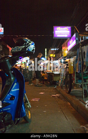 Scooter garé en face de stands de nourriture à servir les clients de Khao San Road at night Banque D'Images