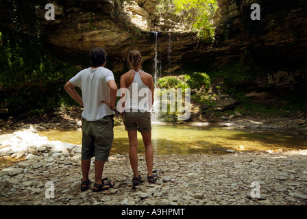 Les touristes à la recherche permanent à un bois et cascade dans les montagnes grecques à l'île de Thassos Grèce Août 2006 Banque D'Images