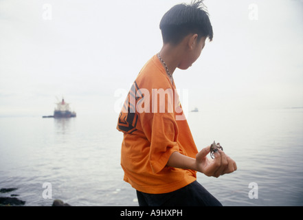 La pêche pour les jeunes de la baie de Manille aux Philippines au crabe Banque D'Images