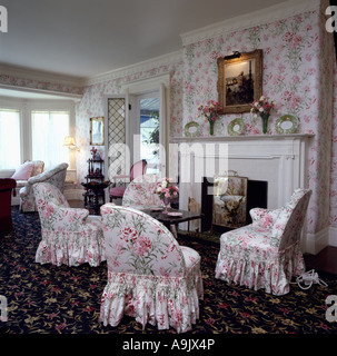 Fleurs roses fond d'appariement et de fauteuils dans années 80, séjour avec cheminée et moquette à motifs blanc Banque D'Images