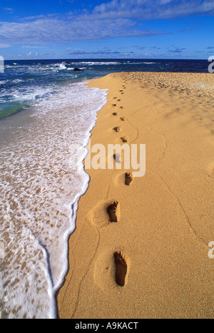 Lumière du soir sur les traces de pas dans le sable le long de la plage de surf à tunnels côte-nord île de Kauai Hawaii Banque D'Images