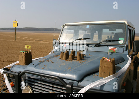 Châteaux et drapeaux en papier construit sur une Land Rover sur la plage à Weston super Mare Banque D'Images