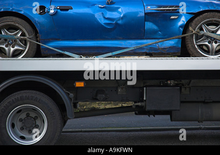 Camion de récupération de voiture transportant une voiture de sport qui a été impliqué en cas d'accident Banque D'Images
