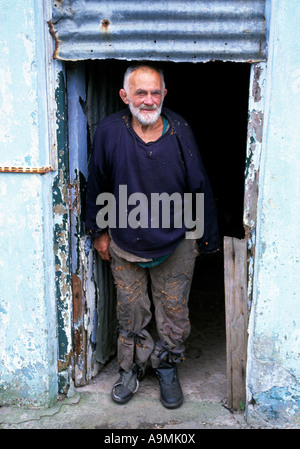 Vieux irlandais homme debout dans l'embrasure de son habitation simple Banque D'Images