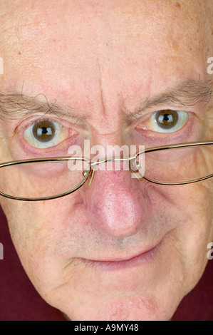 Man close up vertical peering over glasses Banque D'Images