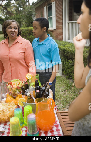 Mature Woman standing avec son fils par table de pique-nique Banque D'Images