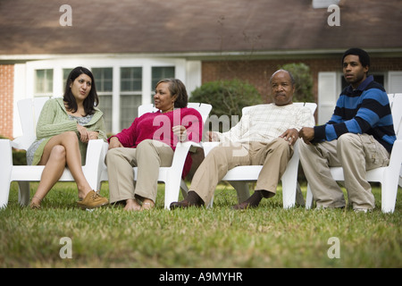 La famille et les amis de vous détendre sur les chaises de parterre en arrière-cour Banque D'Images