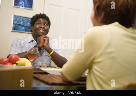 Inter-raciale jeune couple assis à une table à manger Banque D'Images