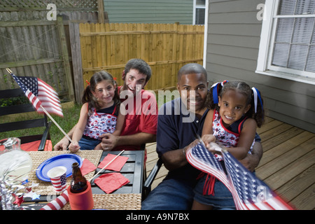 Deux jeunes filles avec les papas au 4 juillet barbecue en agitant des drapeaux américains Banque D'Images