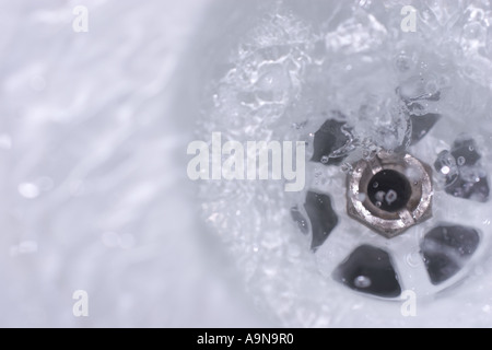 Salle d'eau s'écoule dans le trou du bouchon plughole Banque D'Images