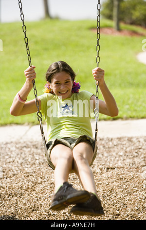 Girl laughing tout en jouant sur une aire de swing Banque D'Images