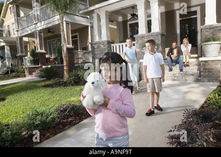 Trois enfants devant leur maison pendant que leurs parents, à partir d'étapes avant Banque D'Images