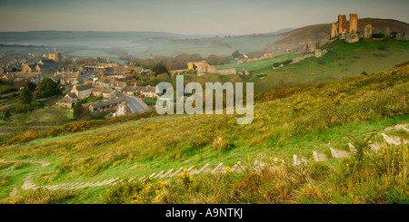 Château à l'abandon et le village de Corfe Castle in early morning light et un ciel clair avec des marches menant vers le bas de la colline Banque D'Images