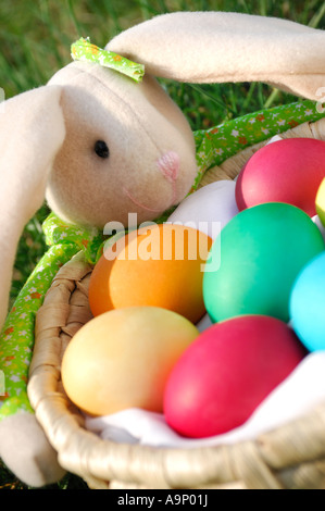 Lapin de Pâques avec un panier plein d'oeufs colorés Banque D'Images