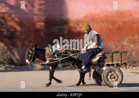 Le Maroc, Marrakech, l'homme sur une charrette tirée par un âne en face du mur de la ville Banque D'Images