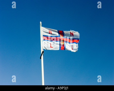 Le pavillon de la Royal National Lifeboat Institution RNLI voler dans un ciel bleu Banque D'Images