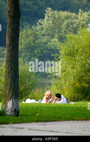 Jeune couple lying on grass in veterans Park Milwaukee Wisconsin USA Banque D'Images