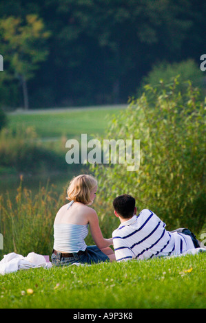 Jeune couple lying on grass in veterans Park Milwaukee Wisconsin USA Banque D'Images