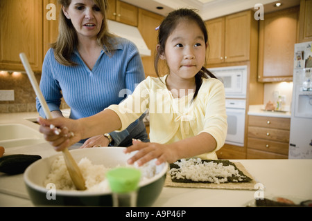 Femme et sa fille dans la cuisine faire des sushis Banque D'Images