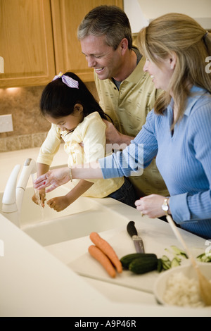 Les parents d'aider leur fille à se laver les mains Banque D'Images