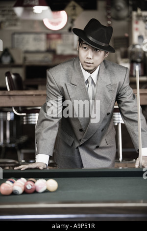 Asian man in pool hall Banque D'Images