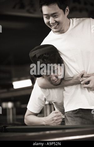 Deux jeunes hommes en jeans et t-shirts combats Banque D'Images