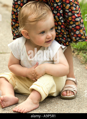 Baby Girl sitting on trottoir avec sœur Banque D'Images