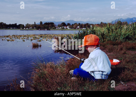 Un jeune garçon à la pêche dans le lac Trout' à 'John Hendry Park à Vancouver British Columbia Canada Banque D'Images