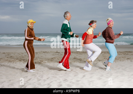 Quatre cadres supérieurs des profils d'exécution sur la plage Banque D'Images