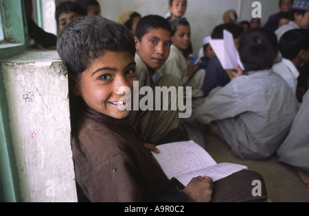 Les jeunes enfants afghans réfugiés recevant quelques heures l'éducation de base d'un projet financé par l'ONG à Quetta Pakistan Balouchistan Banque D'Images