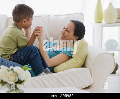 Asian mother and son playing on sofa Banque D'Images