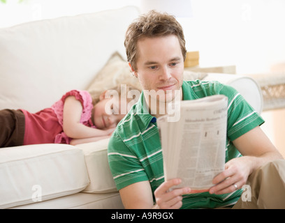 Père et fille se détendre dans salon Banque D'Images