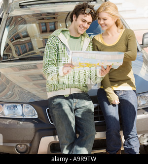 Couple à l'avant de la voiture à la carte à Banque D'Images