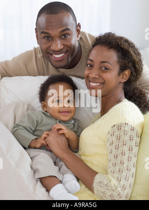 Portrait de parents et bébé sur canapé Banque D'Images