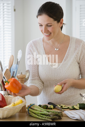 Woman chopping vegetables in kitchen Banque D'Images