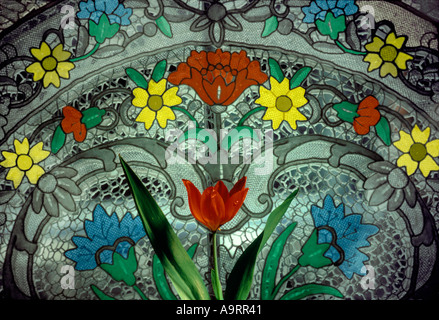 Fleurs de tulipes printanières rouges florissantes devant la vitrine en dentelle et vitrail, Suisse Banque D'Images
