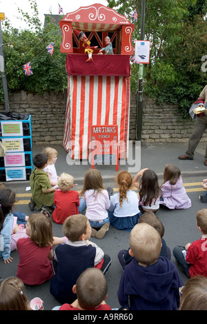 L'enfant regarde Monsieur Jinks Punch et Judy show à Bishops Cleeve jour fleurs près de Cheltenham Banque D'Images