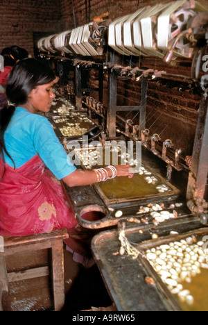 Des femmes qui tiraillement des fils de soie de cocons dans une usine de soie, Bangalore. Inde Banque D'Images