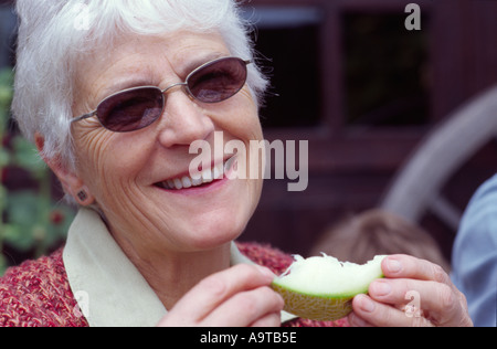 Woman eating slice melon frais extérieur Banque D'Images